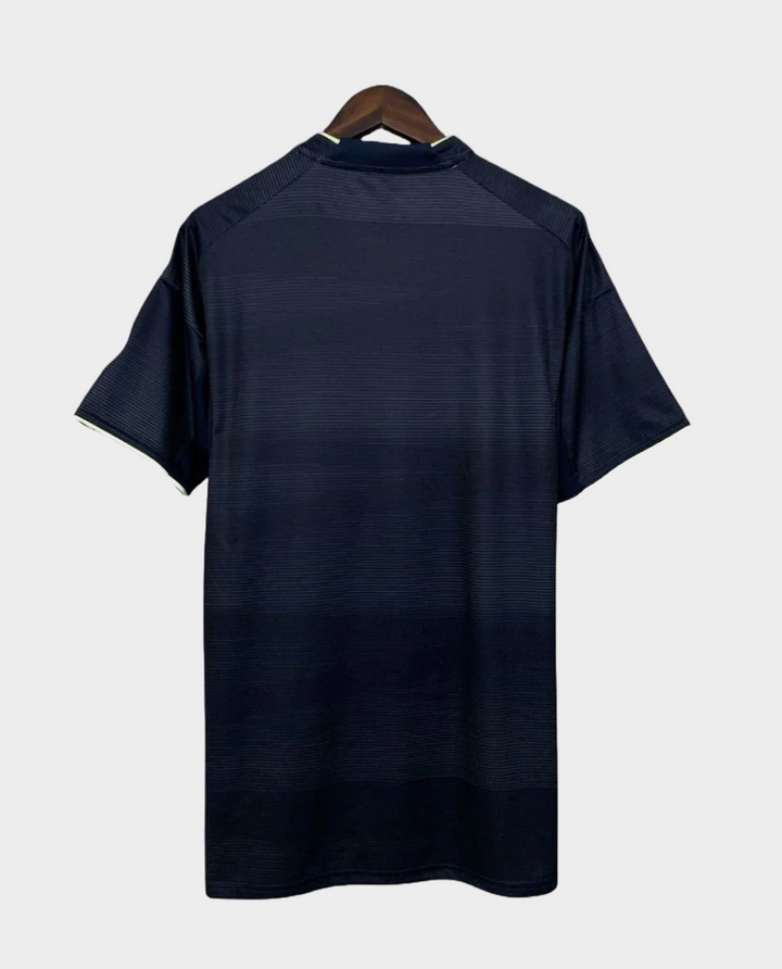 Back view of Real Madrid away jersey 2025 26 in dark color hanging on wooden hanger