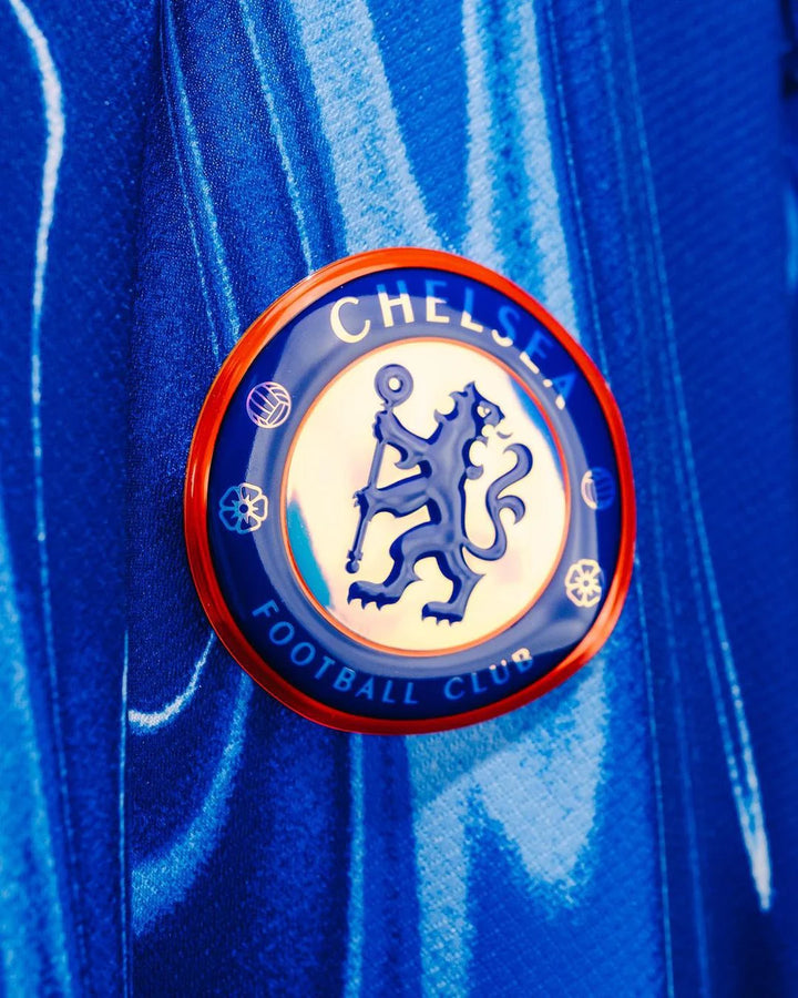 Close-up of Chelsea home jersey 2024 logo featuring the club crest and vibrant blue fabric