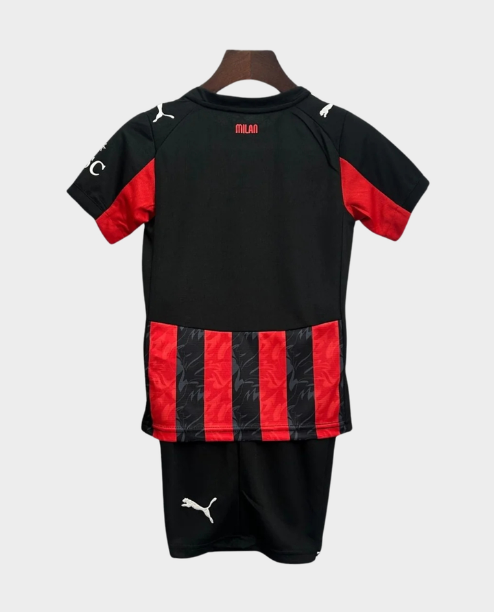 Kids AC Milan home kit 2025-26 featuring black and red striped design with matching shorts