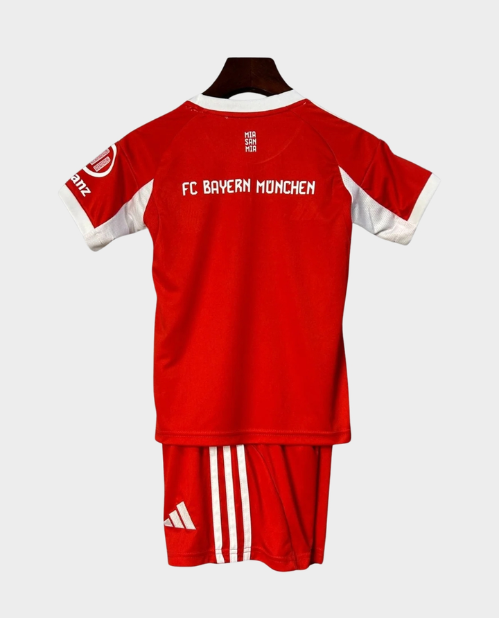 Kids Bayern Munich 2025-26 home kit featuring red jersey and shorts with team logo.