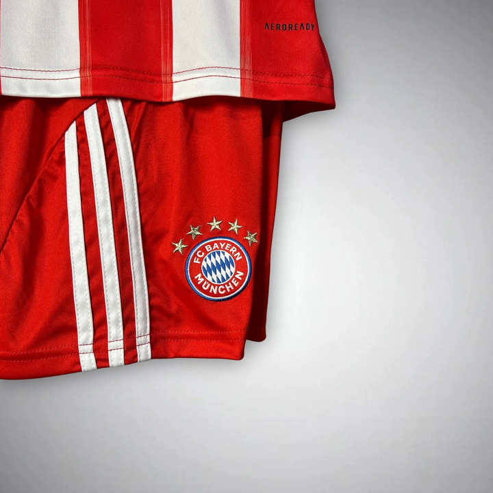 Kids Bayern Munich 2025-26 home kit featuring red and white striped jersey and shorts with club emblem