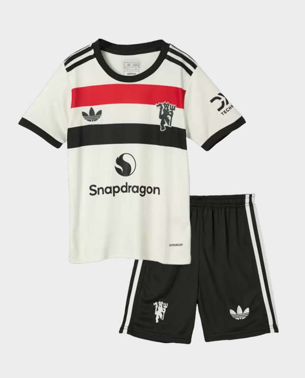 Kids Manchester United jersey 2024 set featuring a white shirt and black shorts with sporty design