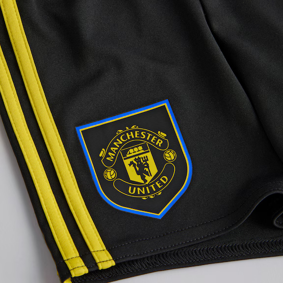 Detailed view of the Kids Manchester United third kit 2025-26 logo on black shorts with yellow stripes