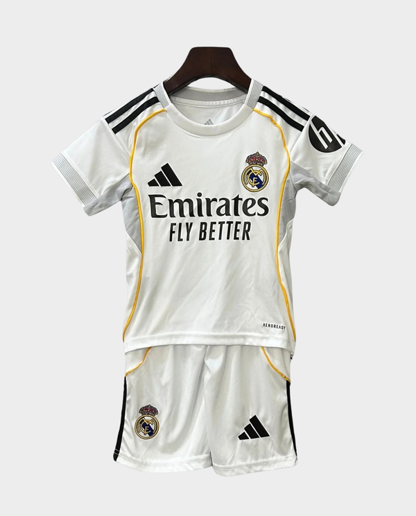 Kids Real Madrid home kit 2025-26 featuring a white jersey and shorts with club insignia