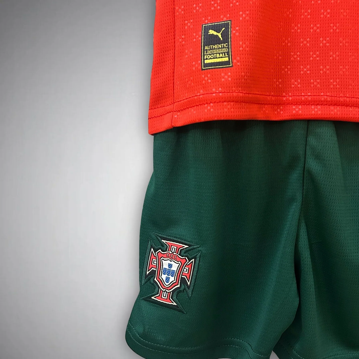 Kids Portugal football kit 2025-26 featuring a red jersey and green shorts with authentic branding