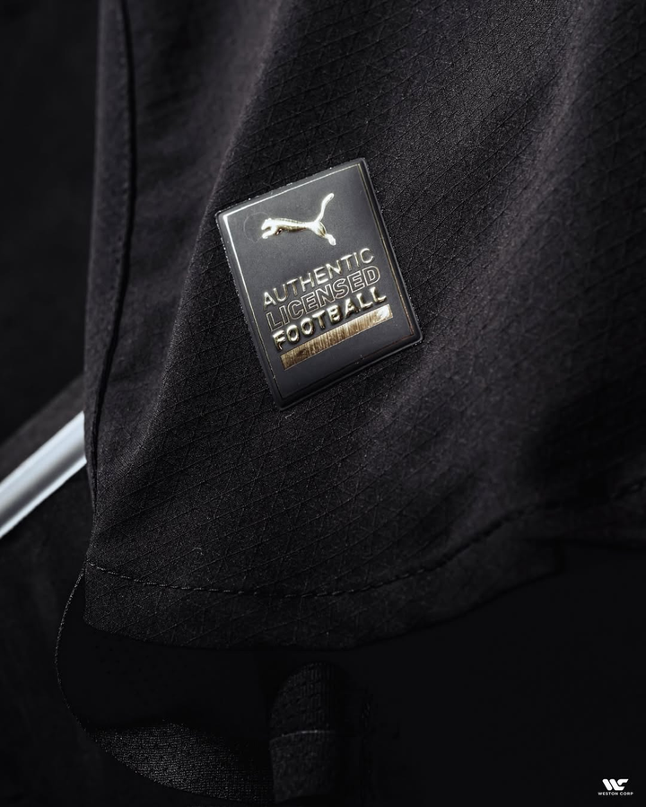 Close-up of Puma authentic licensed football badge on Manchester City away jersey 2025 black fabric