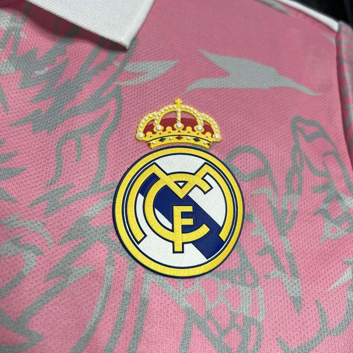 Close-up of Real Madrid pink dragon jersey patch featuring the iconic club logo and crown detail